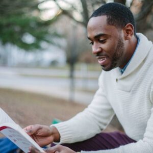 a man reading a book outside