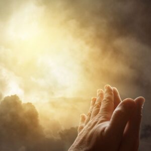 a pair of hands praying towards the sky