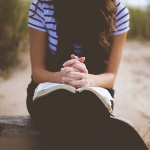 a person sitting with their hands folded on their book