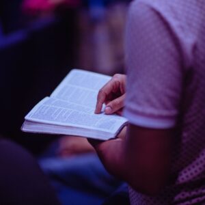 Closeup of someone reading a bible in a dark chapel